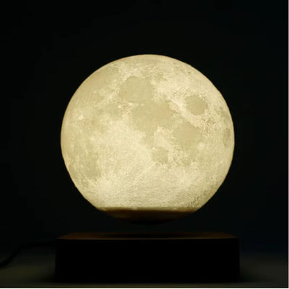 Moon-shaped lamp emitting a warm glow on a dark background