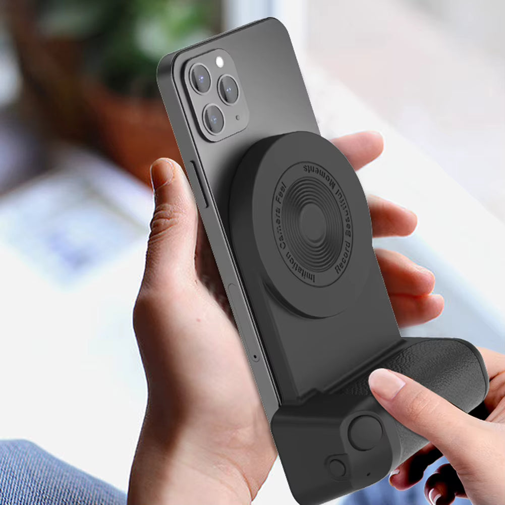 Person holding a smartphone with a black phone case featuring a stand and magnetic attachment.