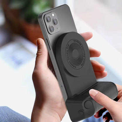 Person holding a smartphone with a black phone case featuring a stand and magnetic attachment.