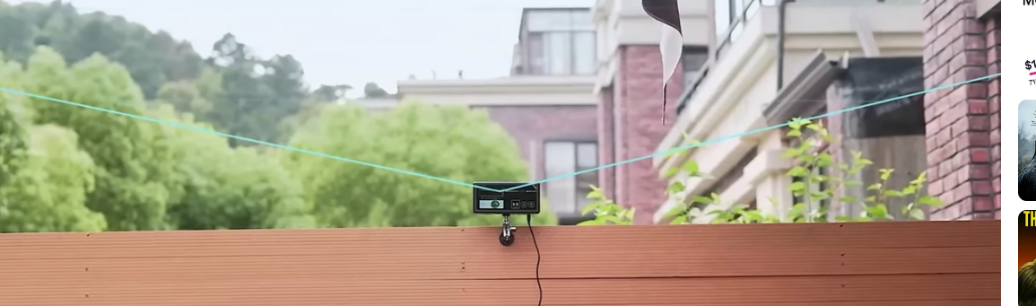 Photon Matrix attached to a green cable on a wooden surface with a blurred background of trees and buildings.