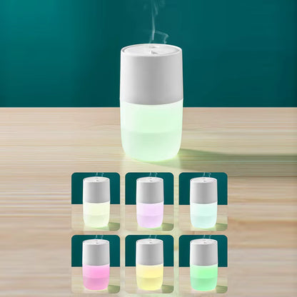 White humidifier emitting mist on a wooden surface with color-changing display.